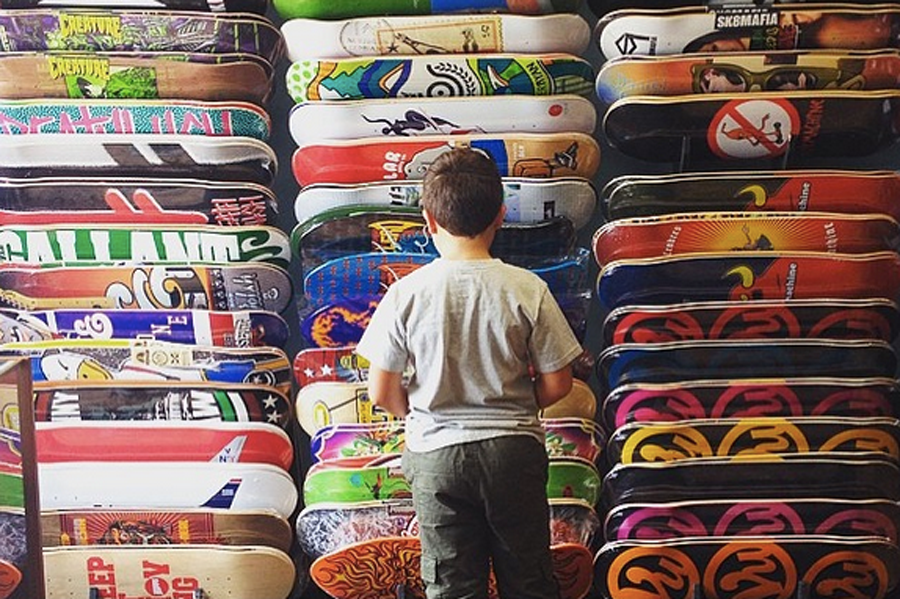 a kid shops for a board from vu skateshop